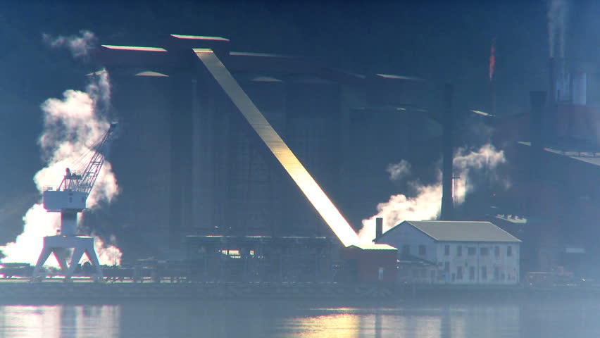 Pollution from oil refinery processing North Sea oil beside glacial fjord