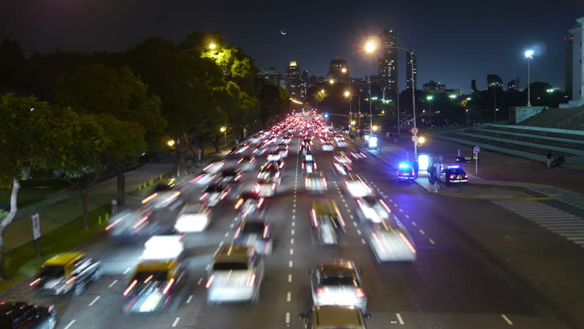 Traffic in the city. Avenue Time-Lapse, Night. Moon going down. Heavy traffic / jam / flowing with blurred motion. Dusk.

