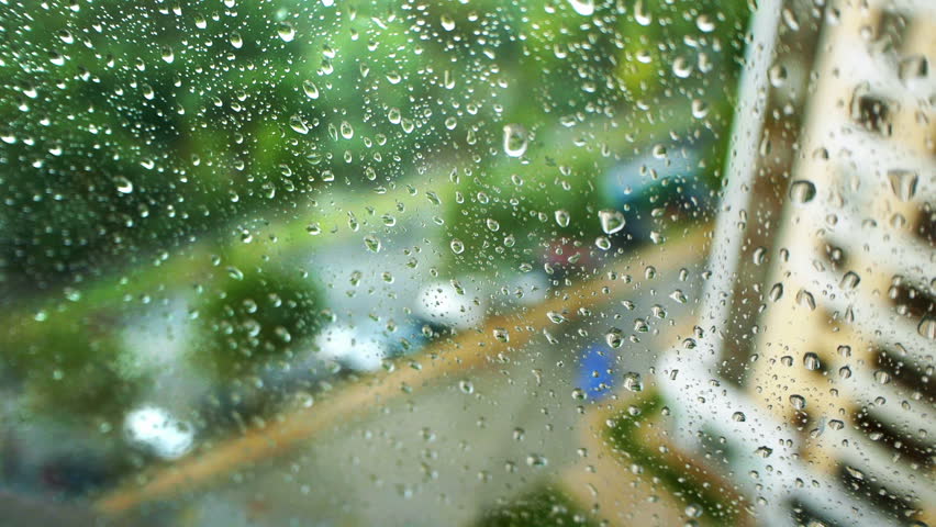 Rain water drops on the window glass on the background of the road traffic

