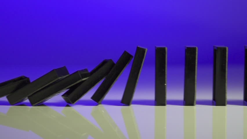 row of dominoes with one falling over on blue background