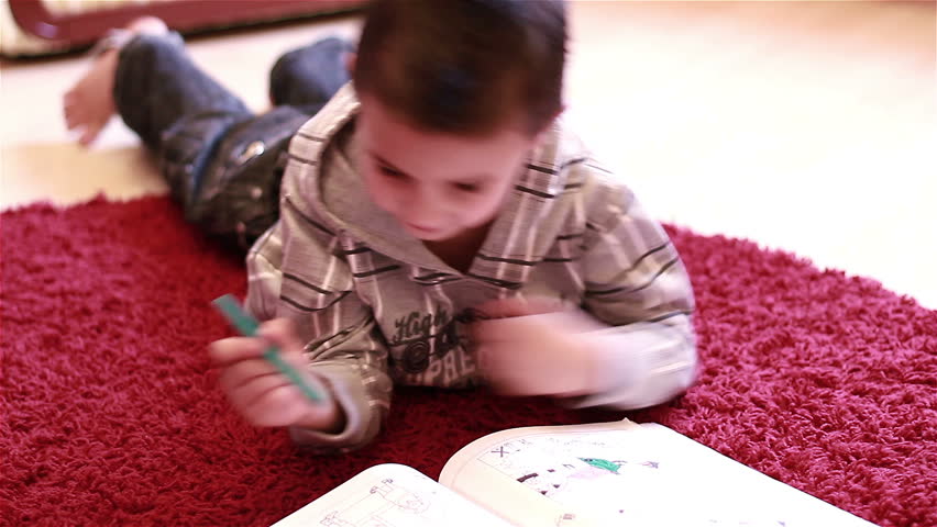 Little boy coloring on floor