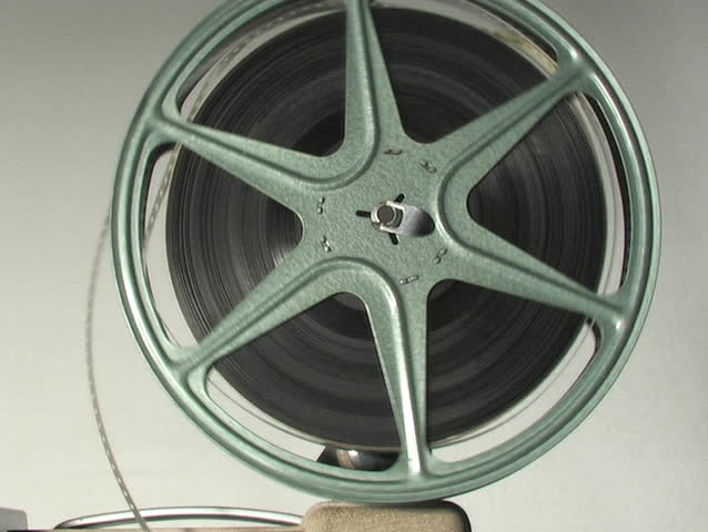 CLOSE UP OF 8MM PROJECTOR REEL IN ACTION.