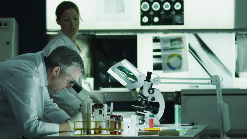 Diverse team of scientists or researchers working together in a dark laboratory, carrying out experiments and analyzing their findings.