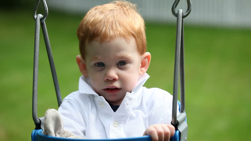 Cute baby boy sitting in swing