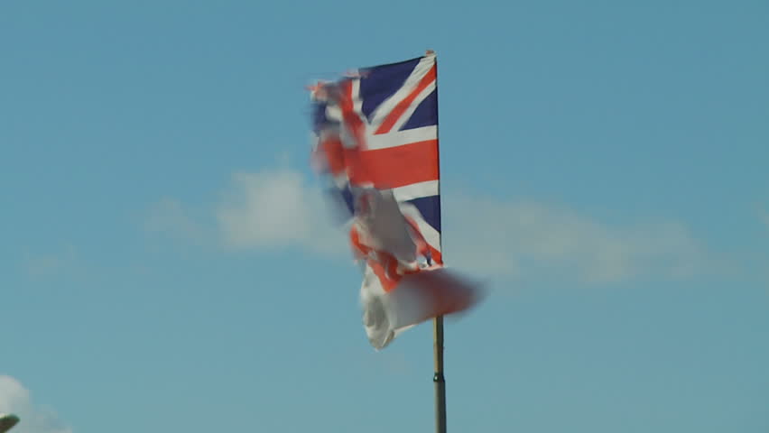 Tattered Union Jack flag flies in wind