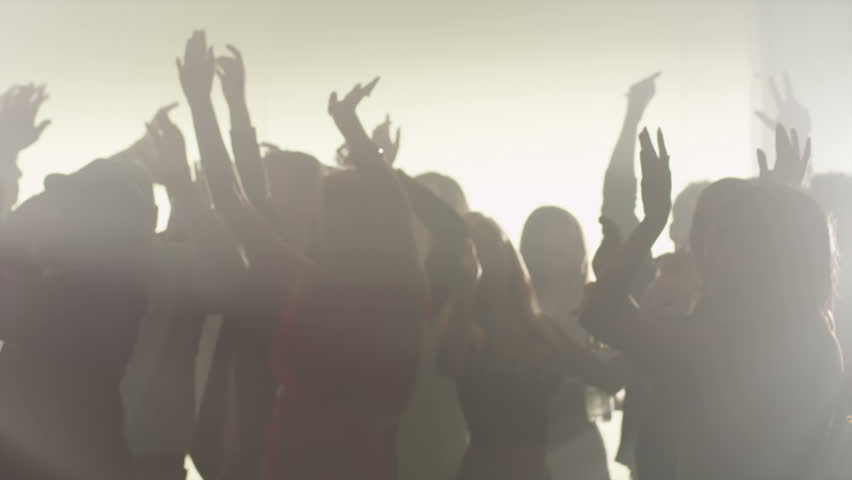 Silhouette in a smokey room of a group of people dancing while at a club
