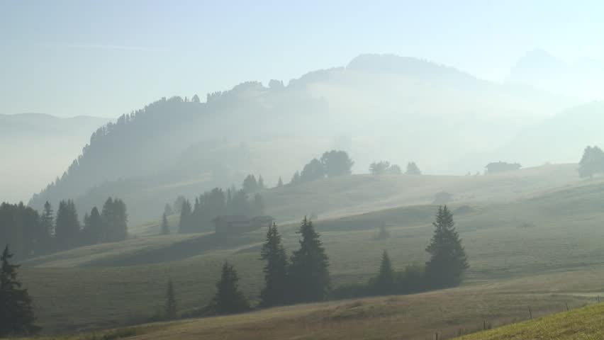 1080i: Panshot of a mountain landscape early in the morning with mist  - Alpe di Siusi - Dolomites. 