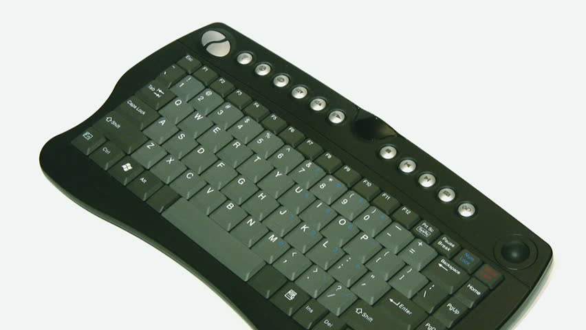Hands using a trackball and left - right mouse buttons at the top of a black compact keyboard, isolated on white.