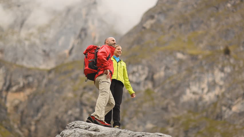 hiking couple reaching mountaintop very happy
