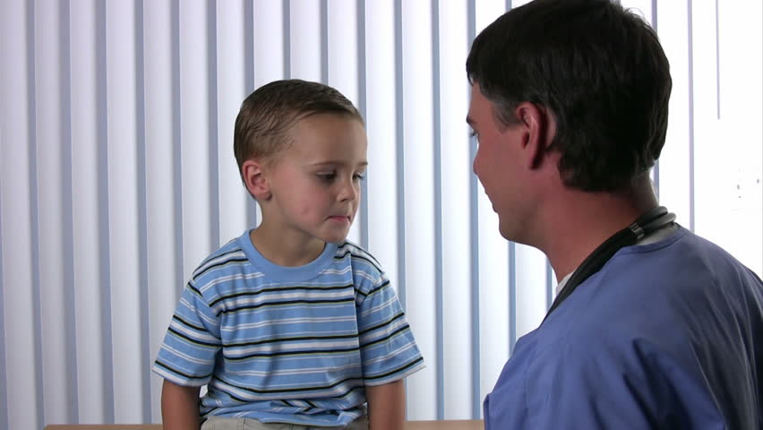 Male doctor listens to a boys lungs using a stethoscope
