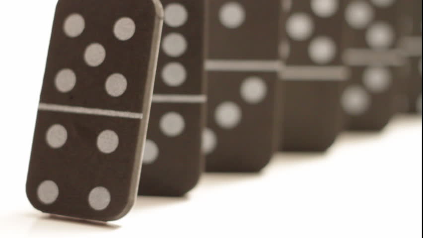A bunch of dominoes falling in sequence, rack focus from the front domino to the back domino, isolated on white.