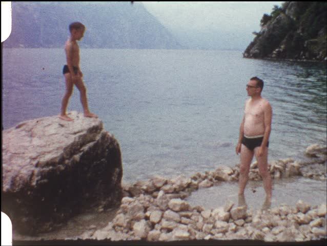 Boy jumping from rock into fathers arms (vintage 8 mm amateur film)