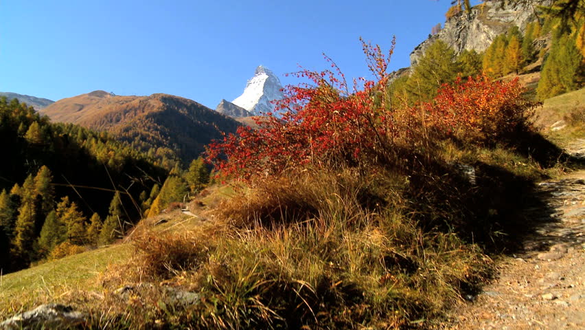 Fall in an alpine meadow, Zermatt, with female hiker & the Matterhorn, motion jib