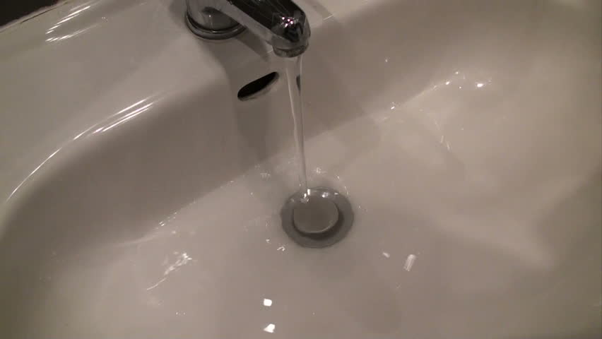 small boy washes his hands