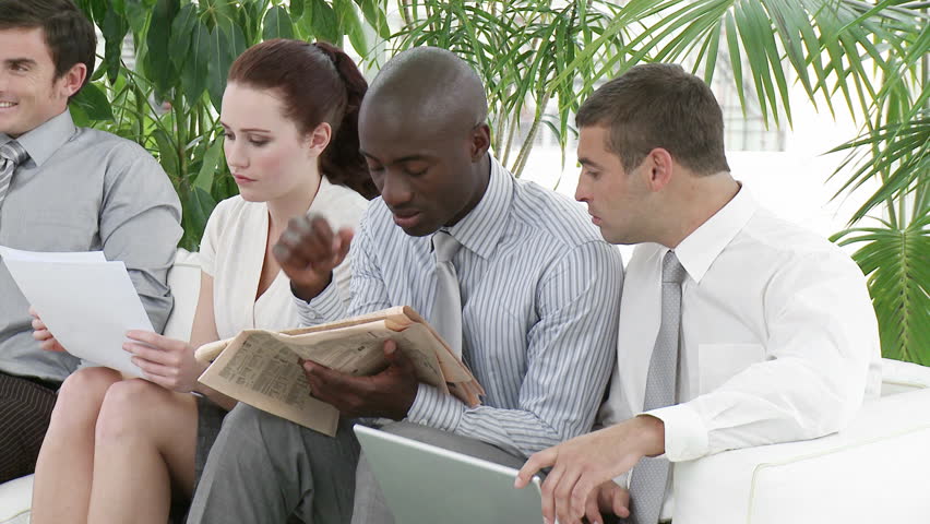 Bored multi-ethnic business people in a waiting room. Footage in high definition