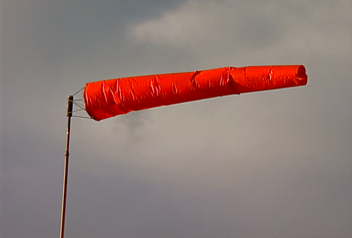A fully extended windsock blows in the wind.