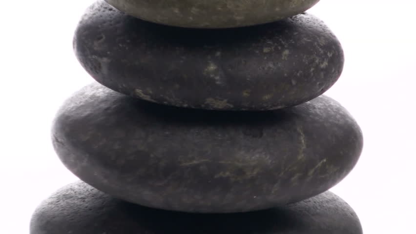 Stack of Zen or massage rocks isolated against white zoom V2