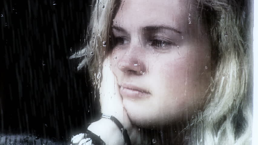 Girl looking out of window a rainy day