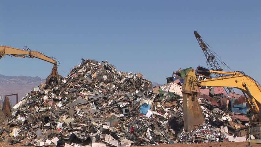 Crane moving piles of scrap metal