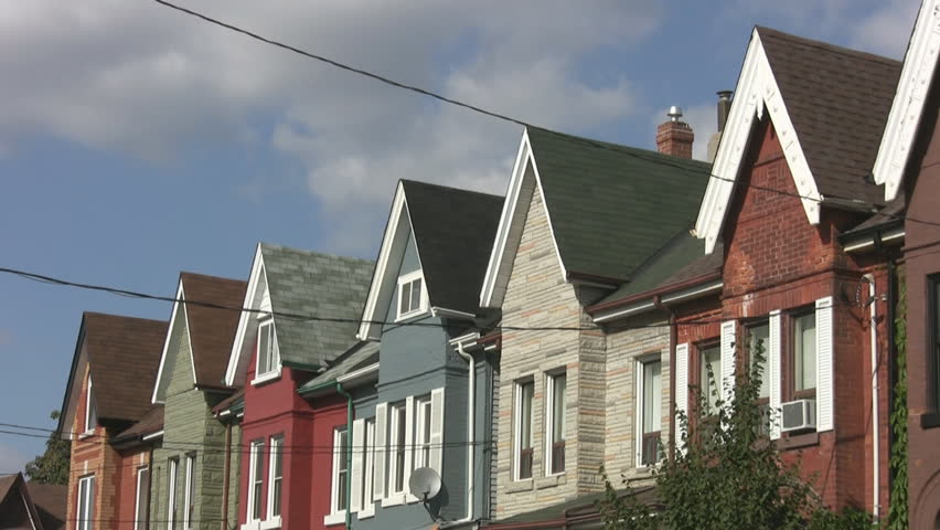 Row of Victorian houses in a Toronto neighborhood. Timelapse clouds move overhead.
