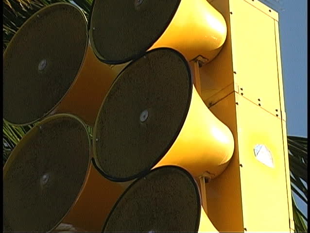 zoom out from close shot of Tsunami siren in Hawaii with palm tree in background