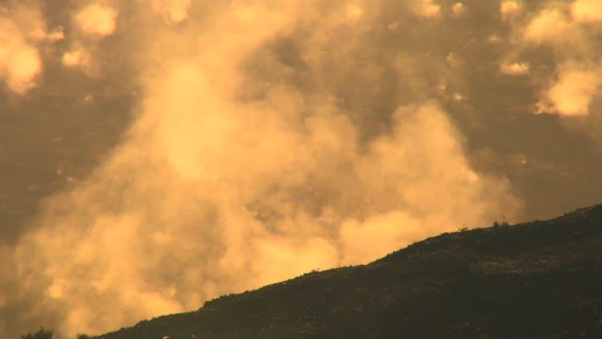 Hot steam energy escaping from a rocky volcanic crater in barren landscape