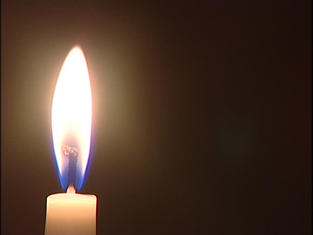 Close up of a burning candle on a black background 