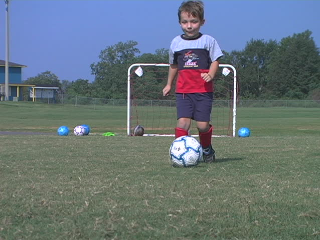 Little boy kicks a soccer ball