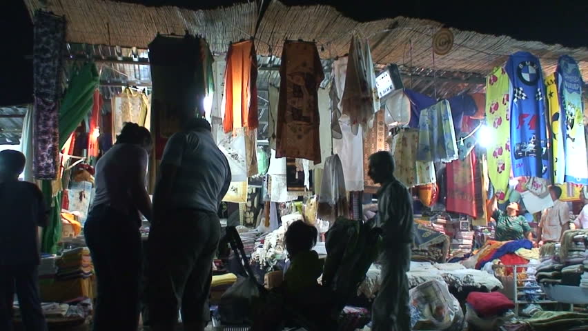 Customers browsing a street market bazaar in the evening