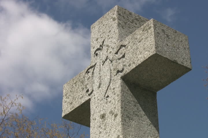 Cemetary cross. Light timelapse. Gravestone marker with light timelapse clouds moving overhead.  