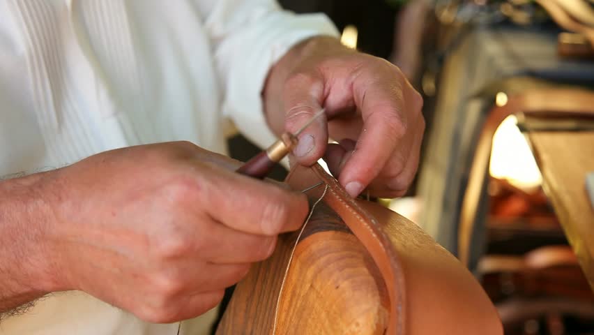 Furrier sewing a piece of leather in the workshop
