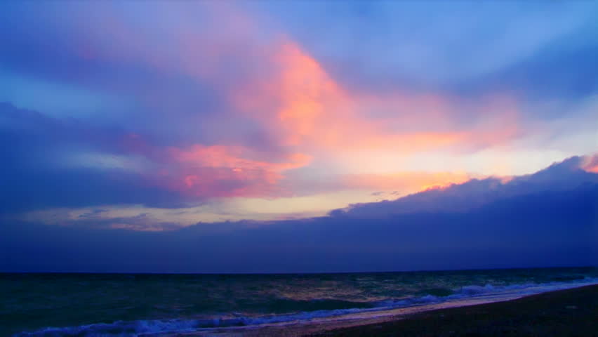 Cloudy sunset. Beautiful clouds penetrated a cocktail sun.