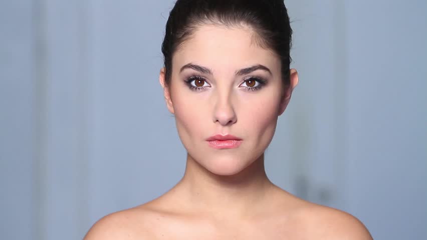 Beautiful young woman applaying cosmetics 
