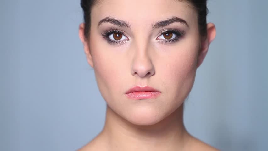 Beautiful young woman applaying cosmetics 