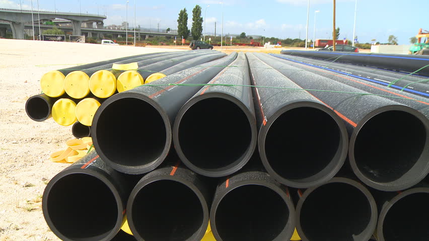 Pipes stacked in construction site dolly shot