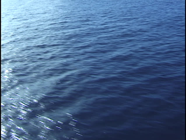 Aerial of water background loop. Flying over blue ocean surface.