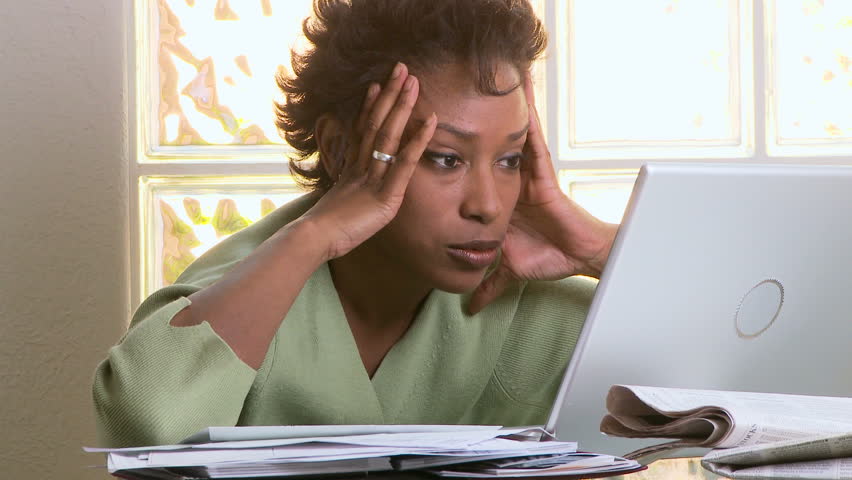 Portrait of concerned woman with laptop and bills