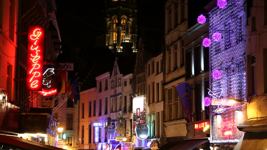 BRUSSELS, BELGIUM - JULY 10, 2010: Neon lights in a neighborhood popular among tourists, Rue du Marche-Aux-Fromages/Kaasmarkt near the Grand Place. Ambient voices and noises of nightlife in Brussels.