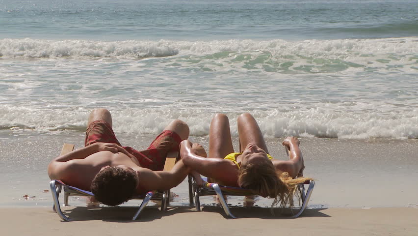 Woman walking into ocean after laying in lounge chair with boyfriend