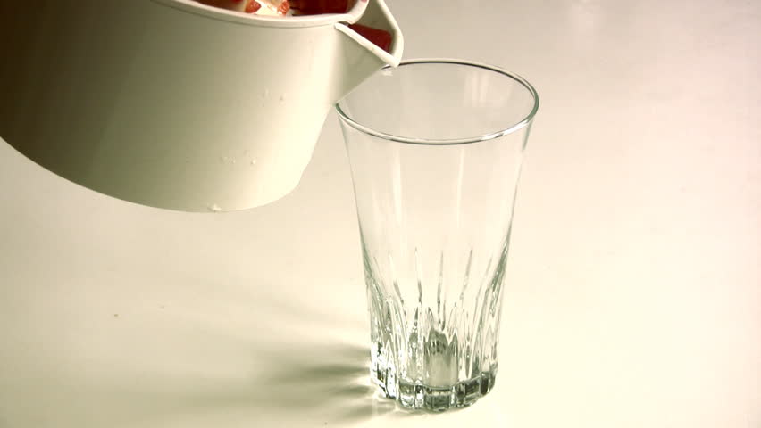 Red juice being poured into a glass. 