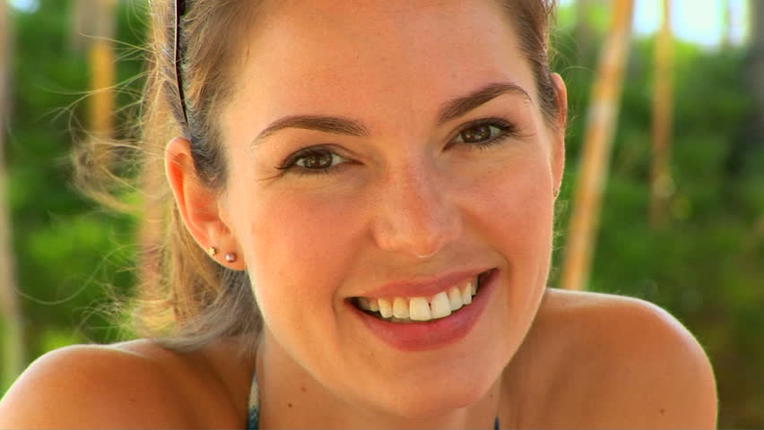 Casual close up portrait of young woman smiling outside