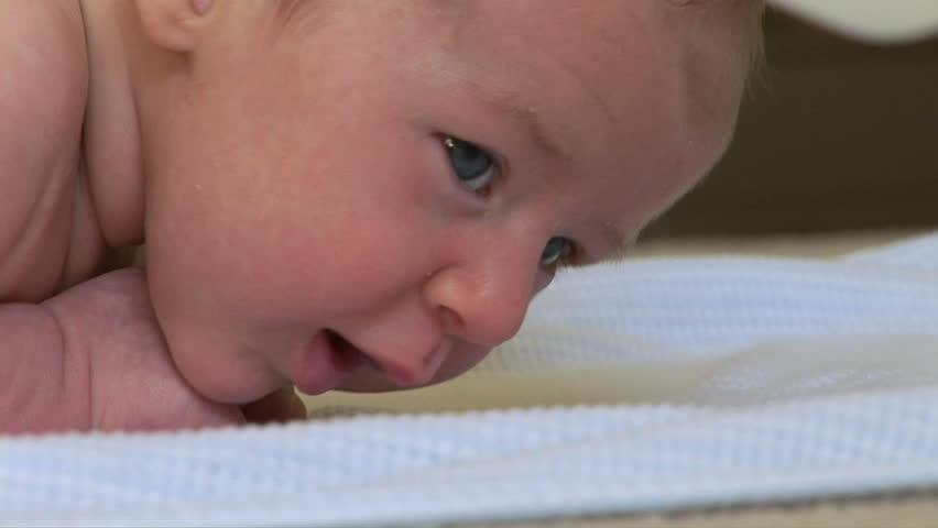 Close up of newborn baby laying on blanket