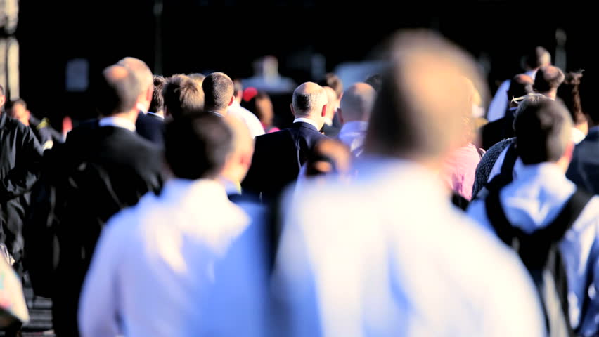 Crowds of early morning commuters walking to work in London during the summer. 