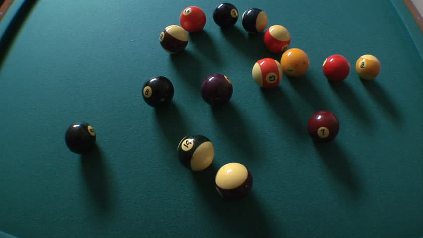 This is an overhead shot of billiards balls being racked and then breaking. shot with a fish-eye lens.