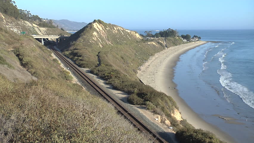 Train by ocean goes through tunnel 