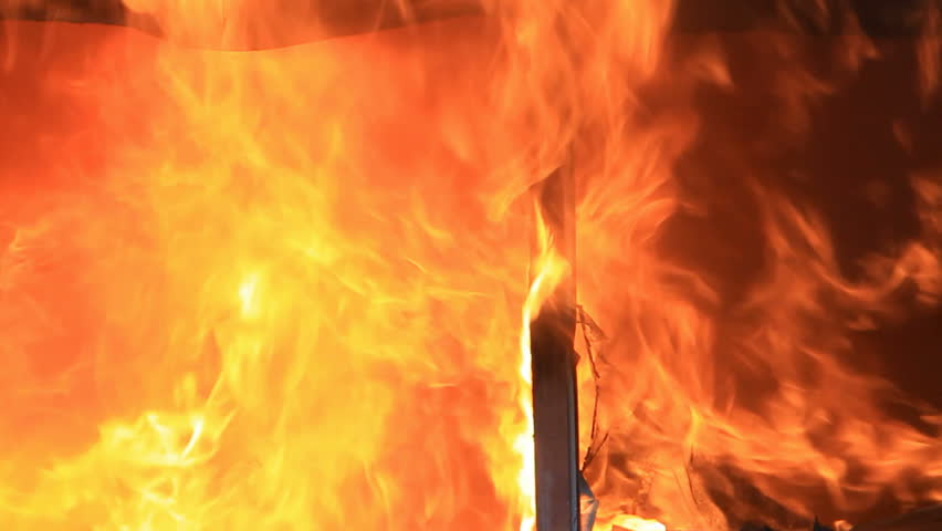 Fire intense house burning with flames and smoke coming through broken window. 