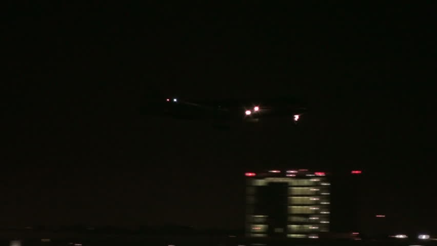 Plane swoops into airport for a smooth night landing.  1920x1080