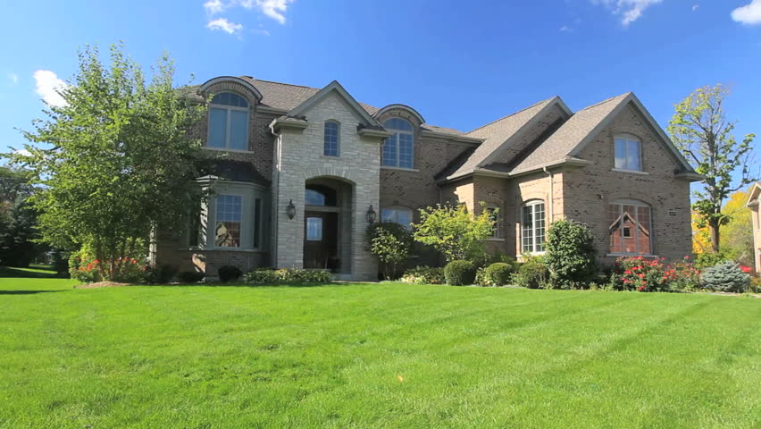 Two children run into frame, followed by their parents, as they walk to the front door of their luxury home 