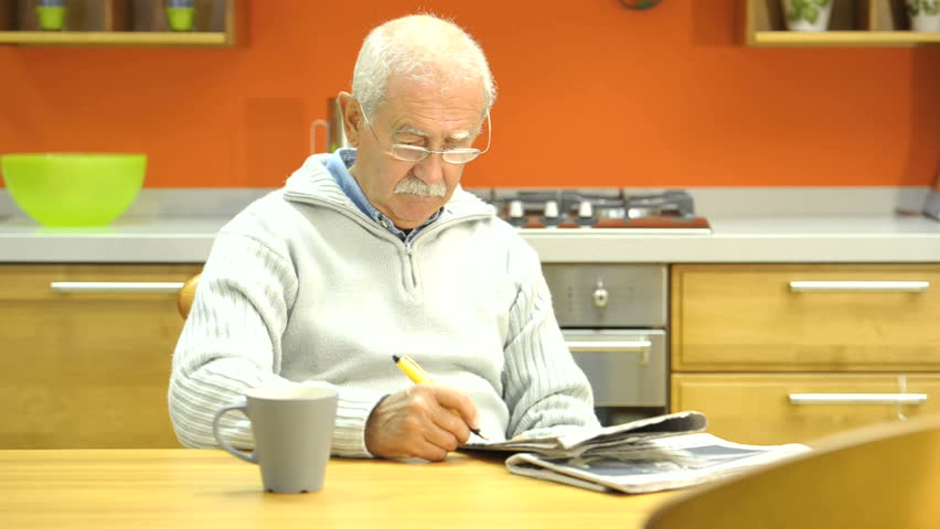 Senior man doing crossword puzzle;  HD: Photo JPEG.