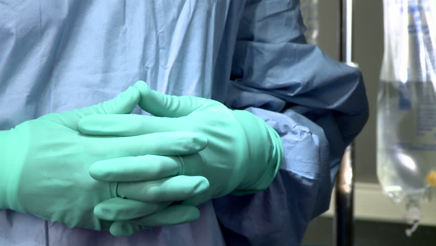 The hands of a surgical nurse exchange instruments with the hands of a surgeon 